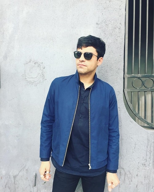 A picture of Sean Teale wearing blue jacket and sunglasses.